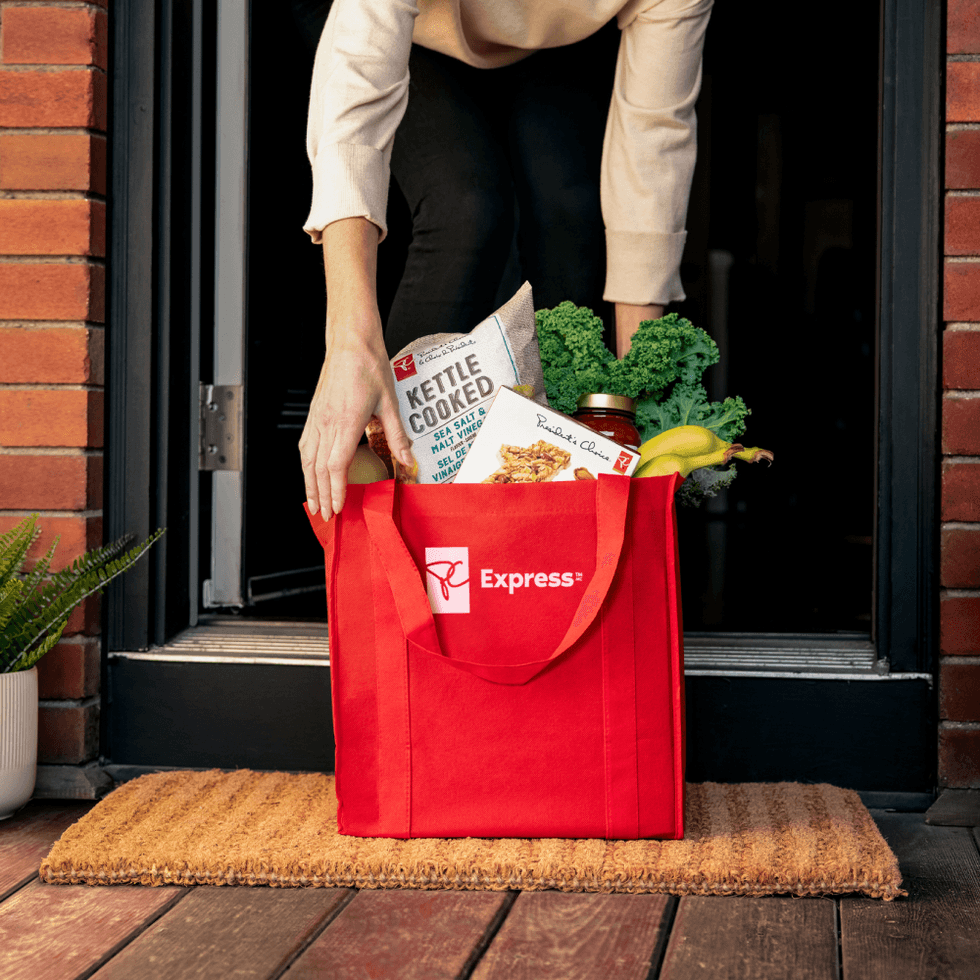 A PC Express bag full of groceries delivered to someone's front porch.