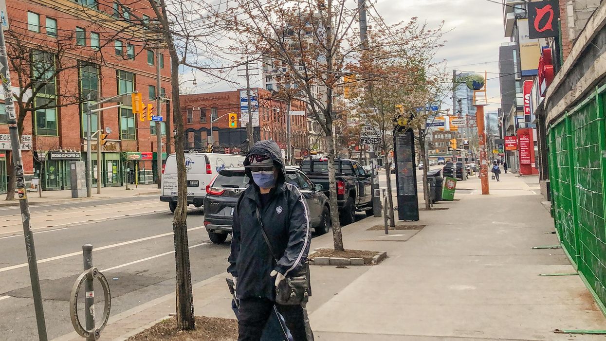A pedestrian wearing a mask in Ontario.