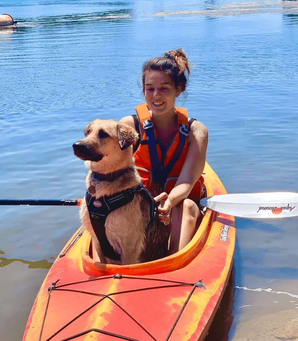 A person and a dog in a kayak.