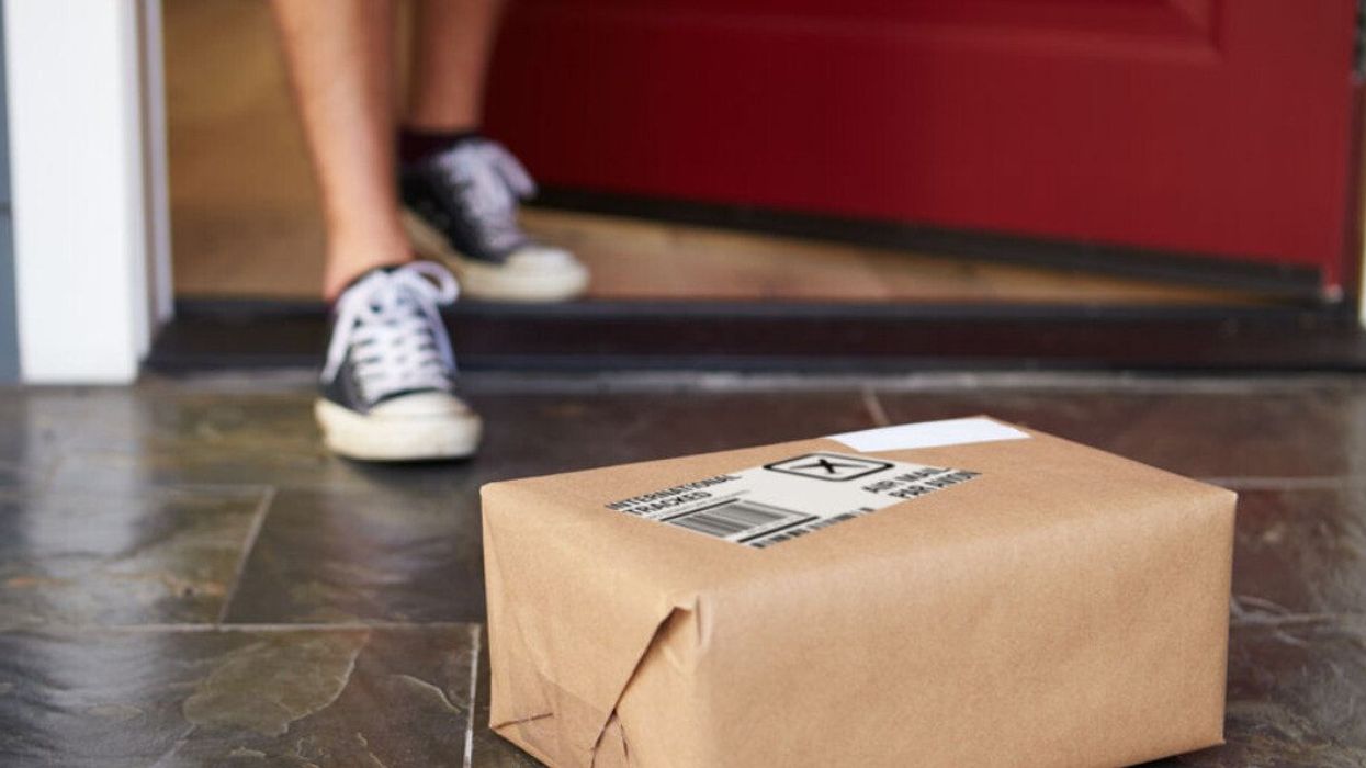 A person collecting a package delivered to their front door.