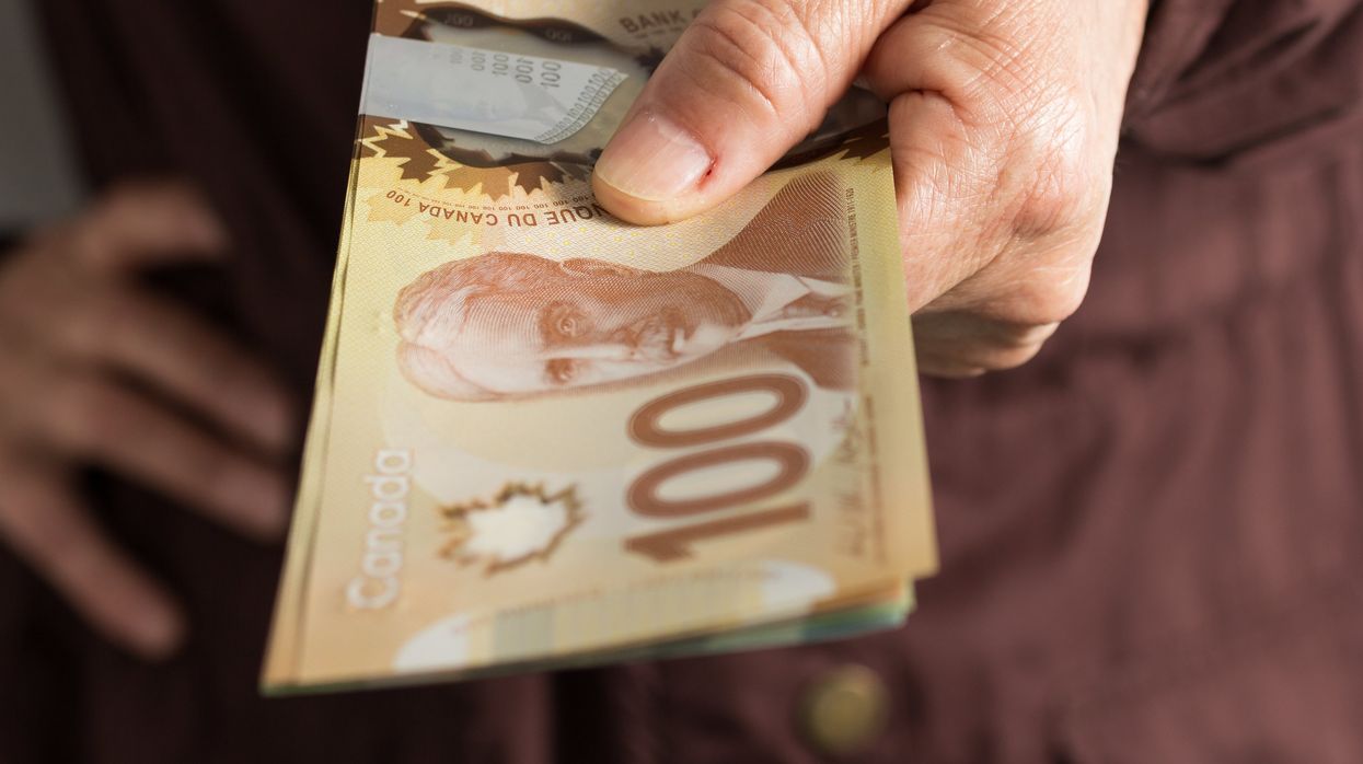 A person holding $100 bills.