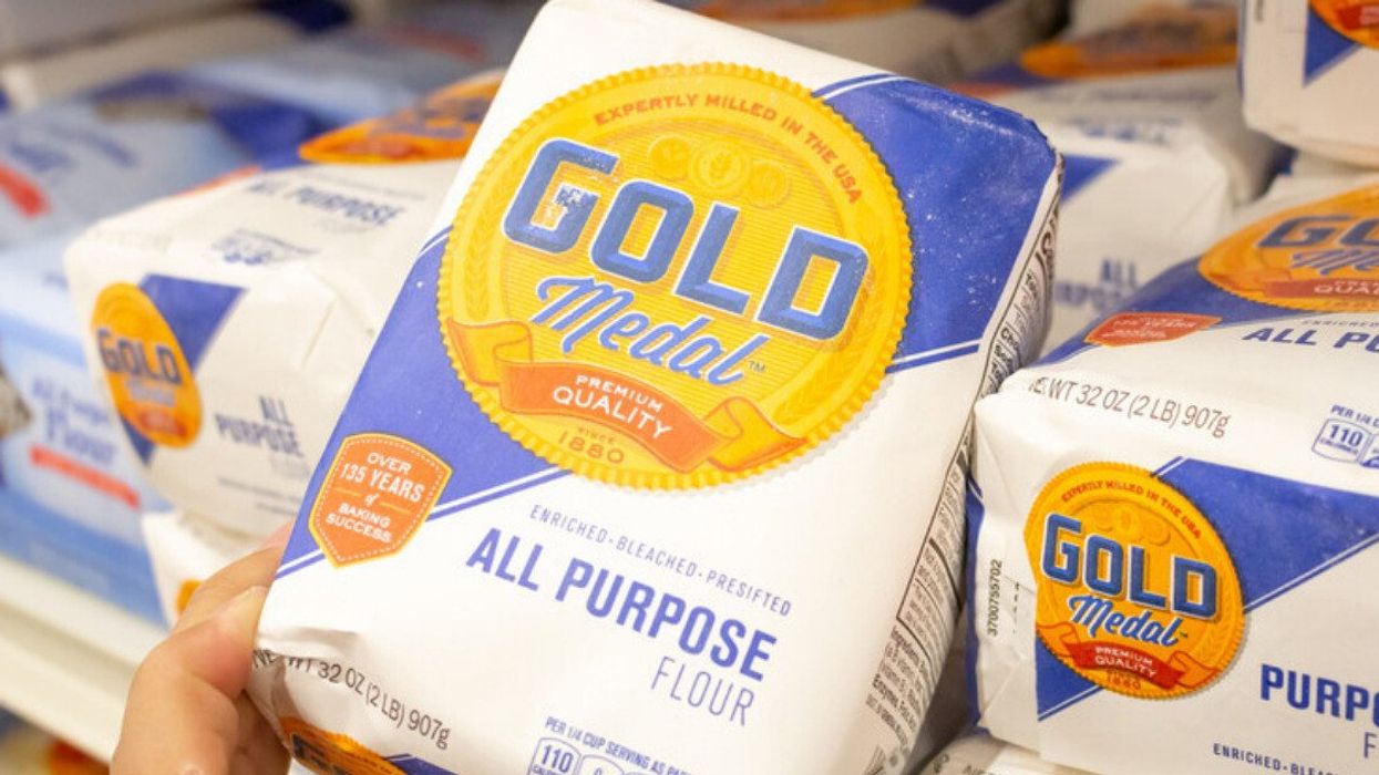 A person holding a bag of Gold Medal's flour.