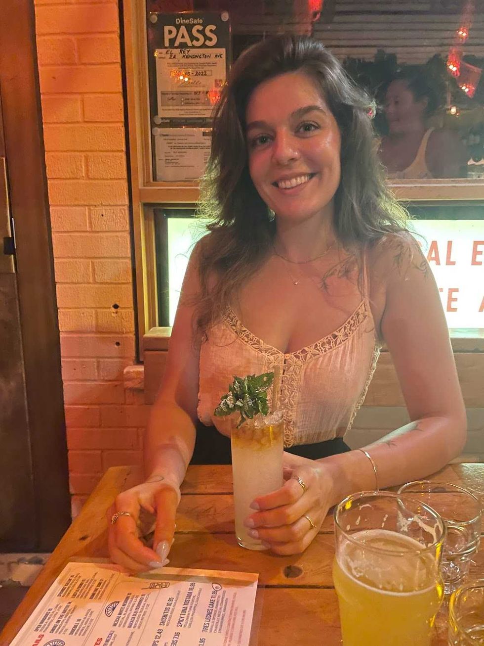 A person holding a beverage at a table.