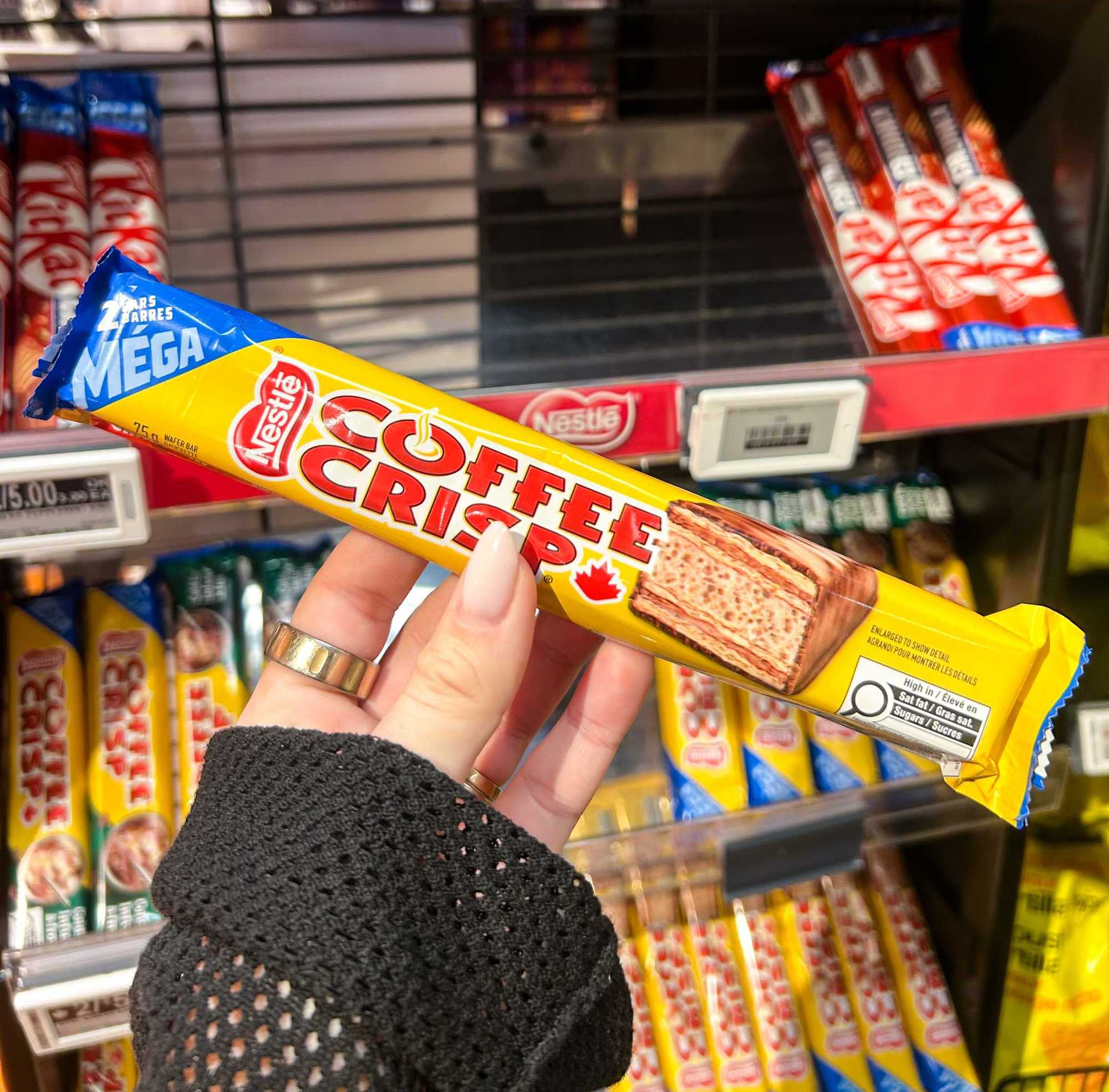 a person holding a coffee crisp chocolate bar in their hand
