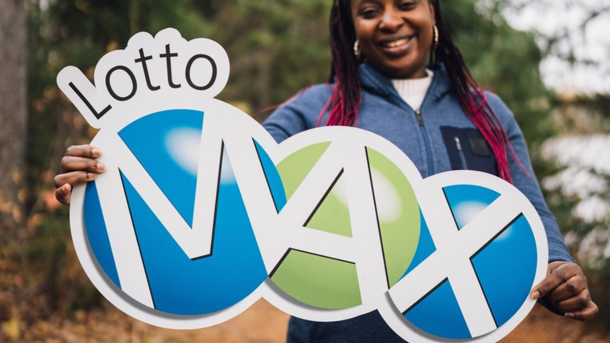 A person holding a Lotto Max sign.