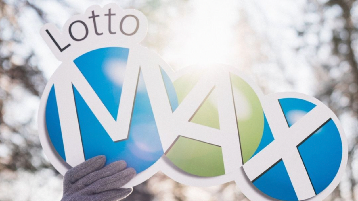 A person holding a Lotto Max sign.