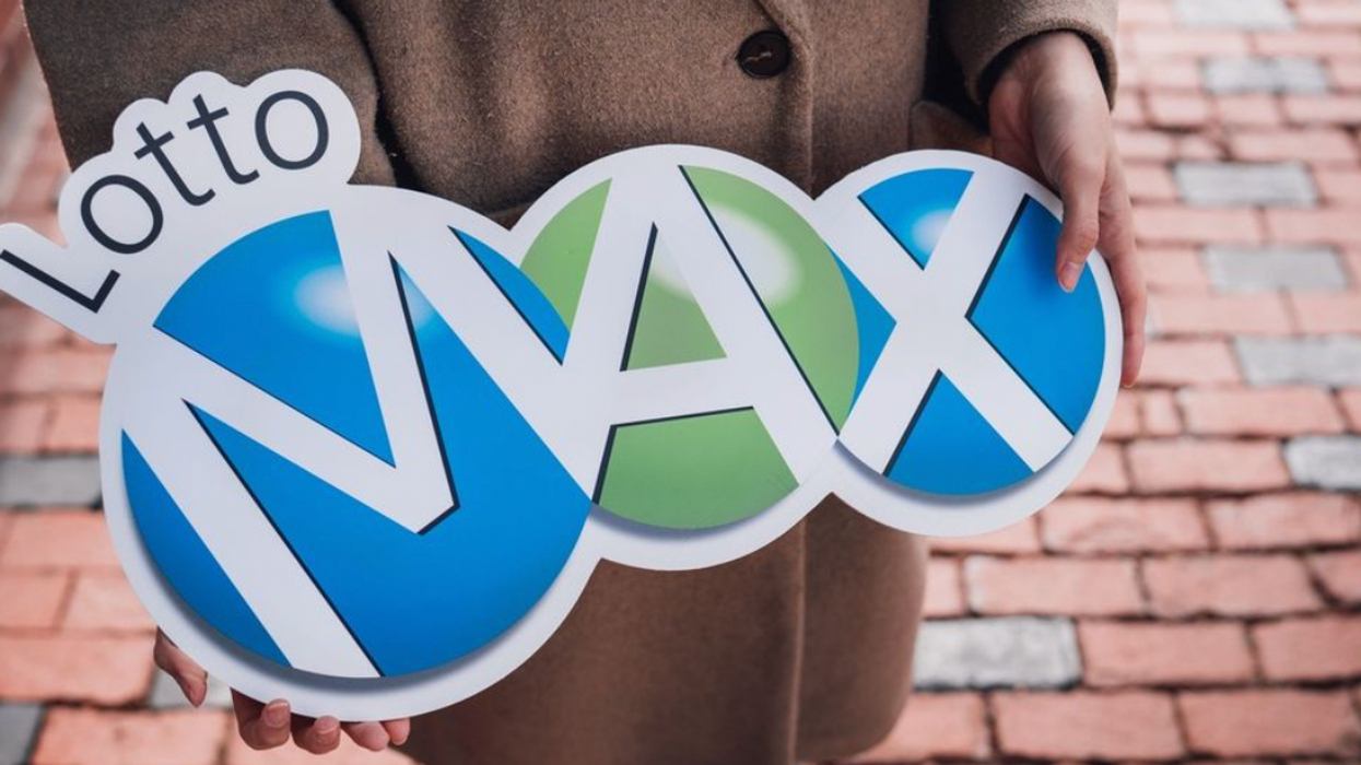 A person holding a Lotto Max sign.