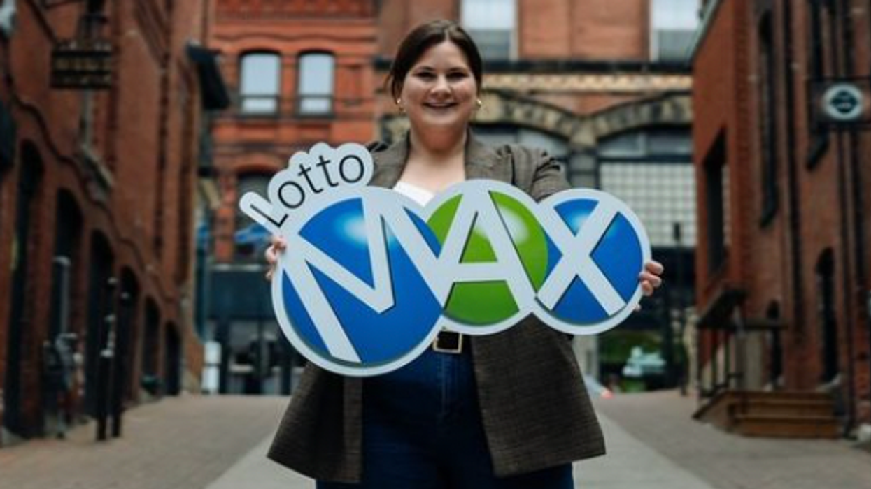 A person holding a Lotto Max sign.