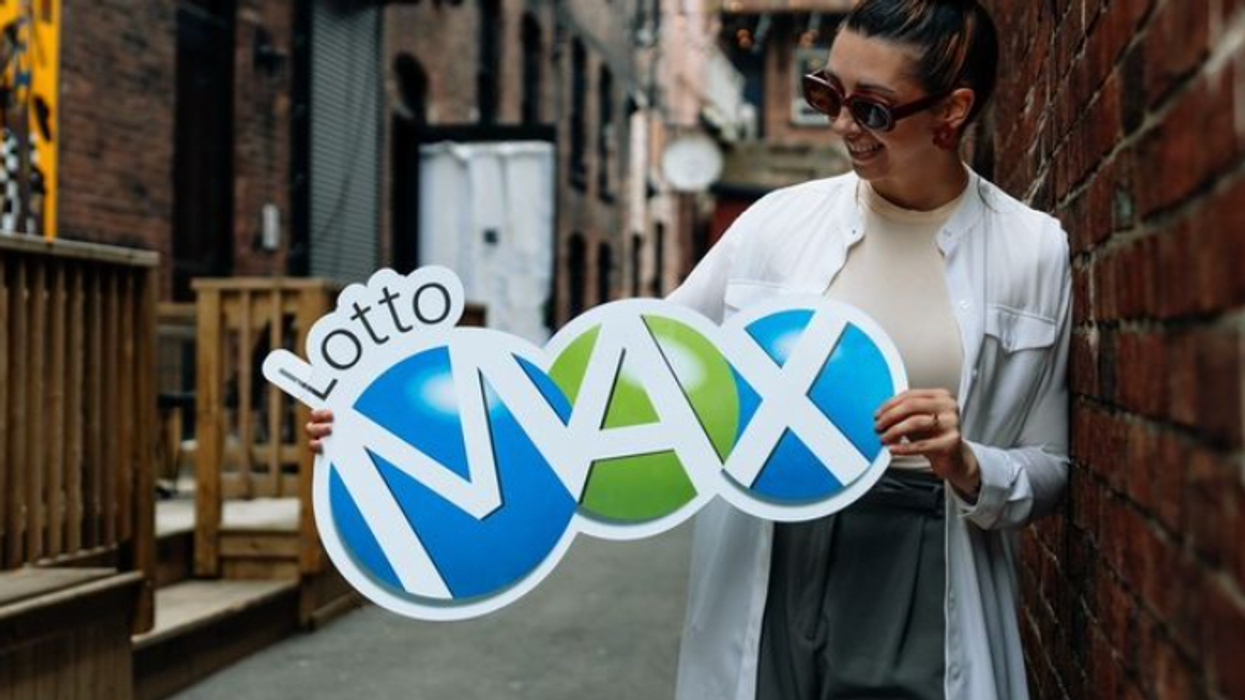 A person holding a Lotto Max sign.