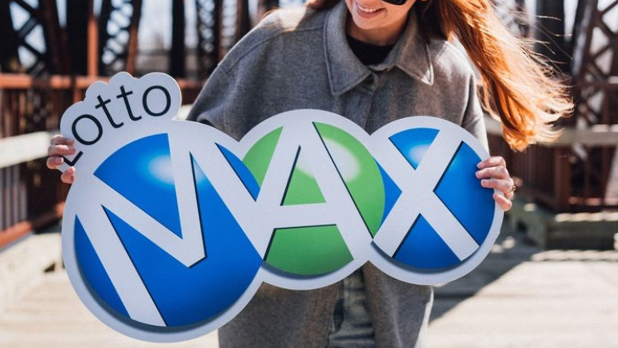 A person holding a Lotto Max sign.