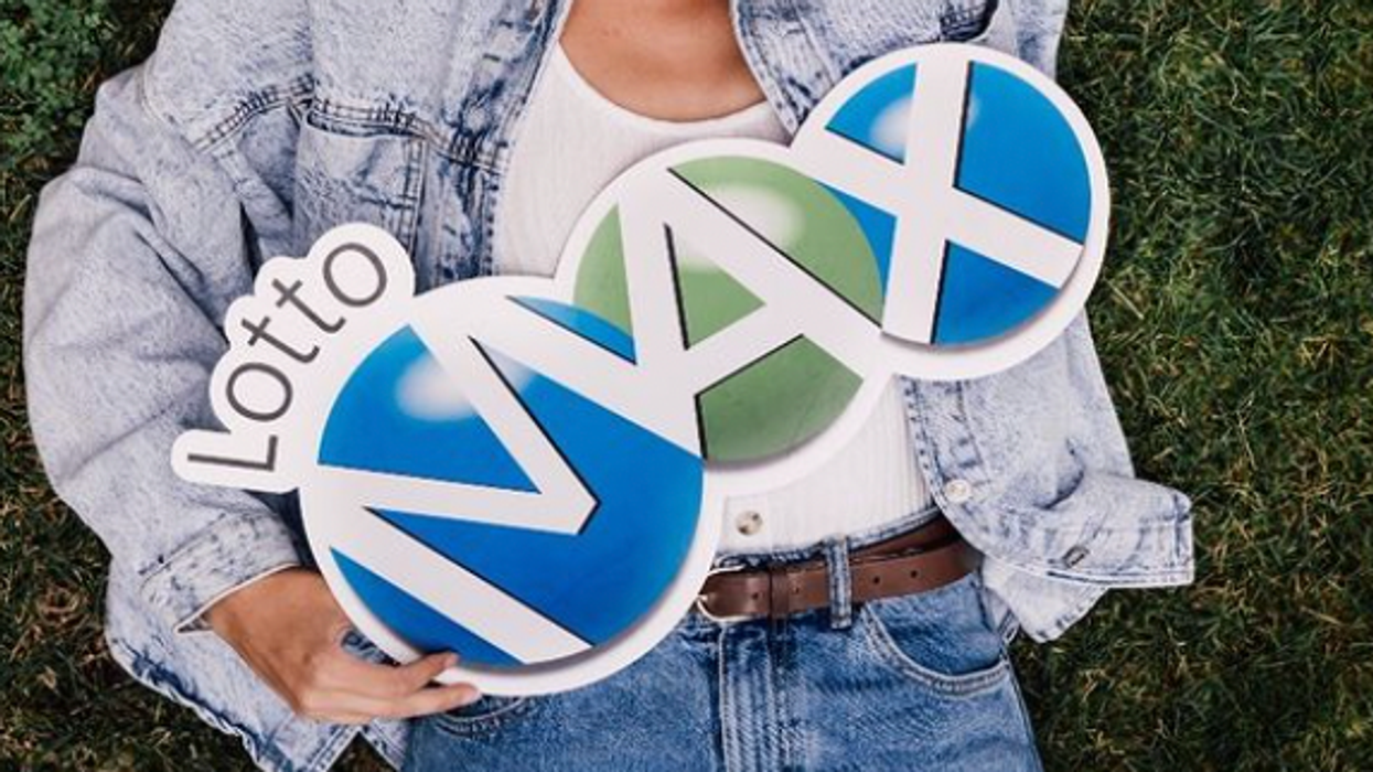A person holding a Lotto Max sign.