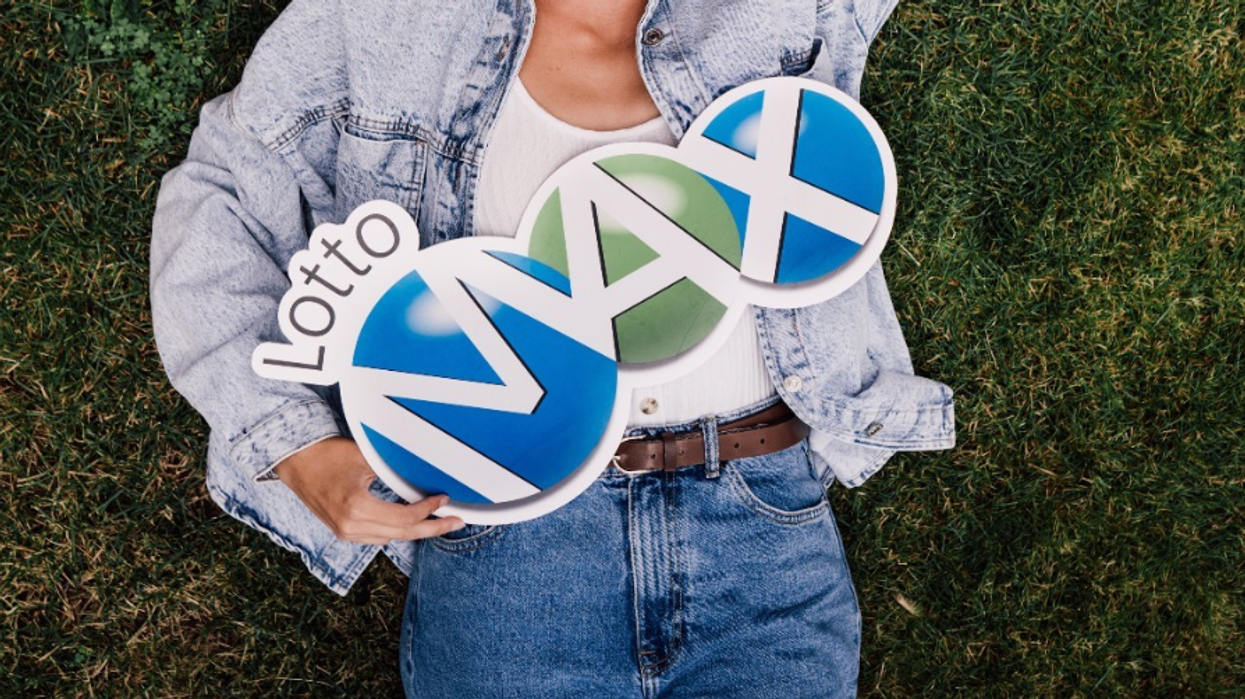 A person holding a Lotto Max sign.