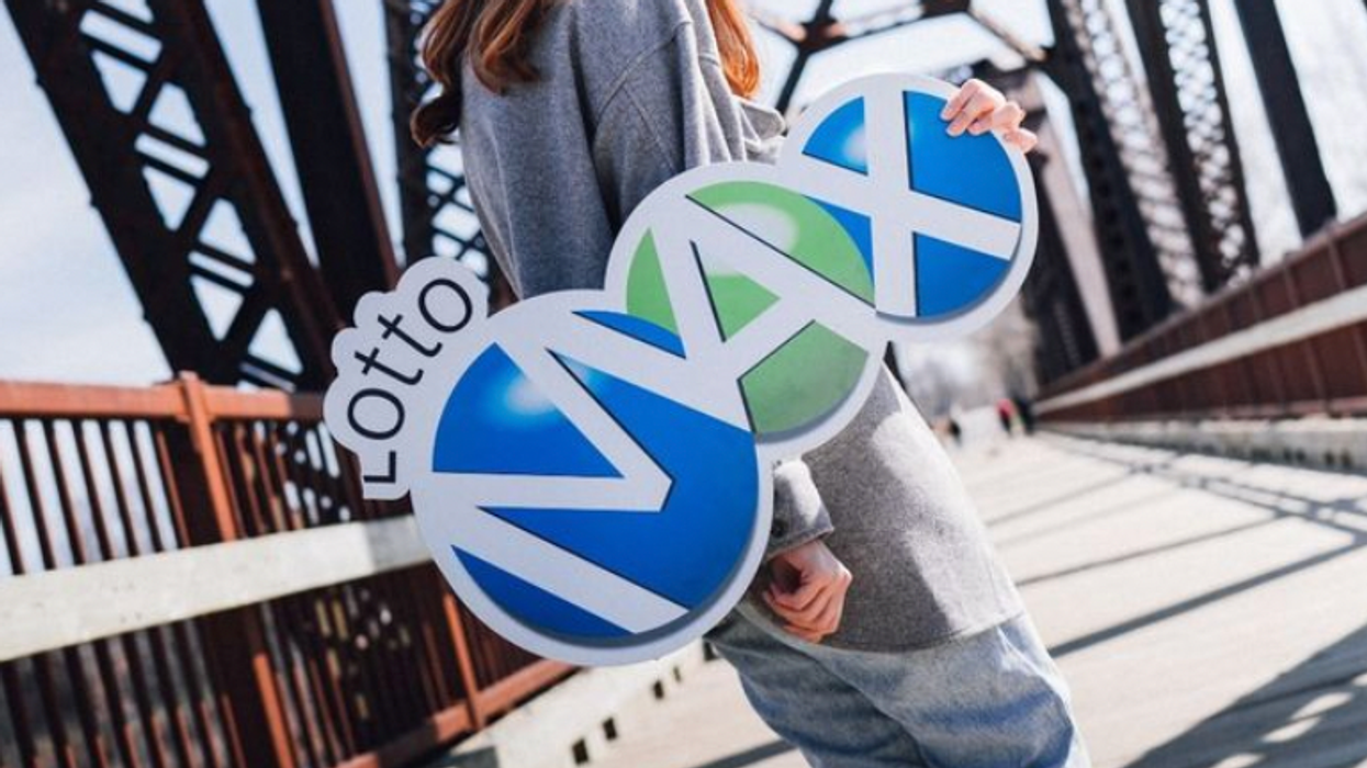 A person holding a Lotto Max sign.