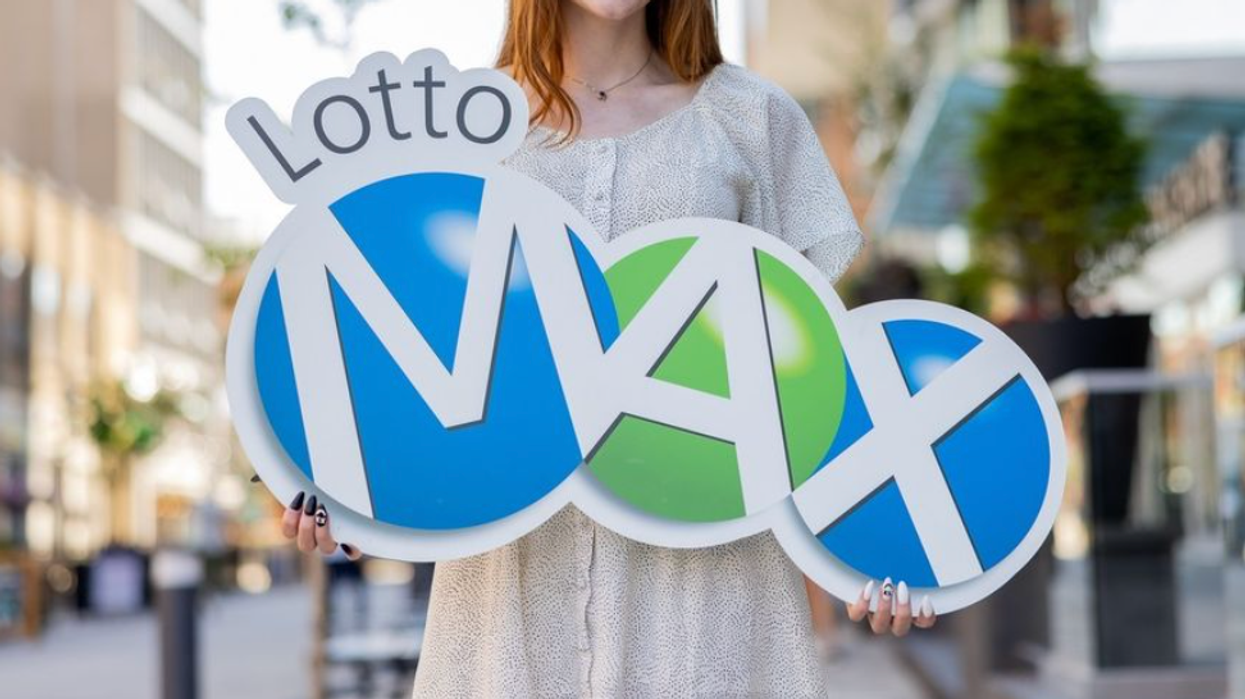 A person holding a Lotto Max sign.