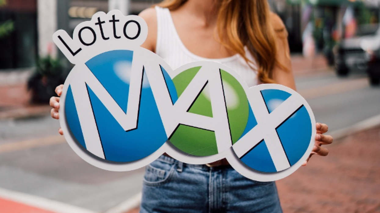 A person holding a Lotto Max sign.