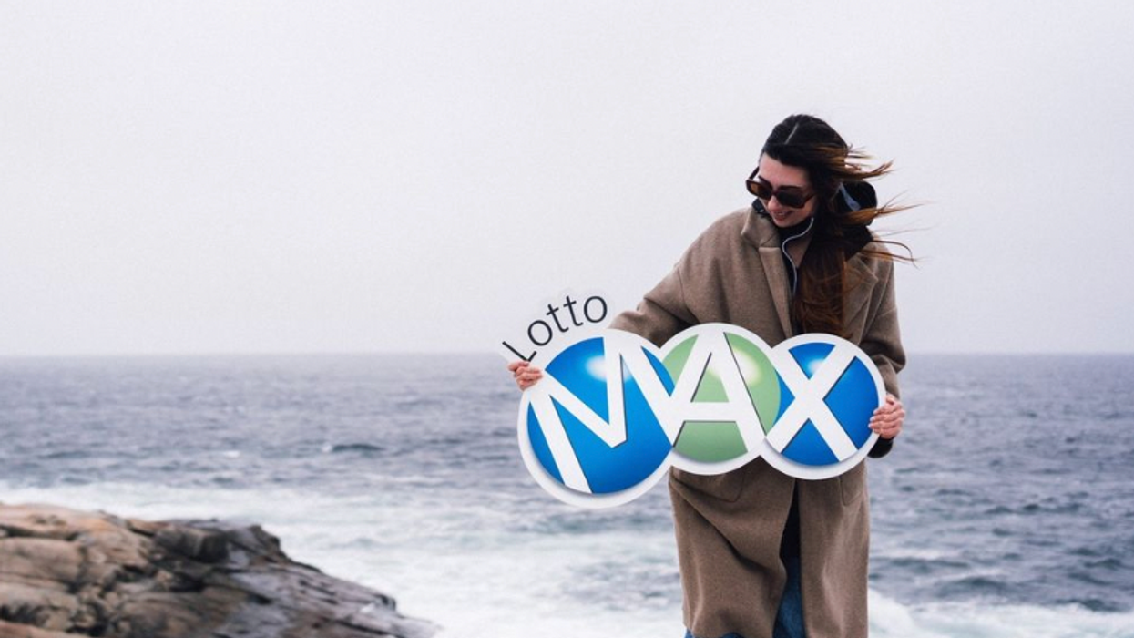 A person holding A Lotto Max sign.