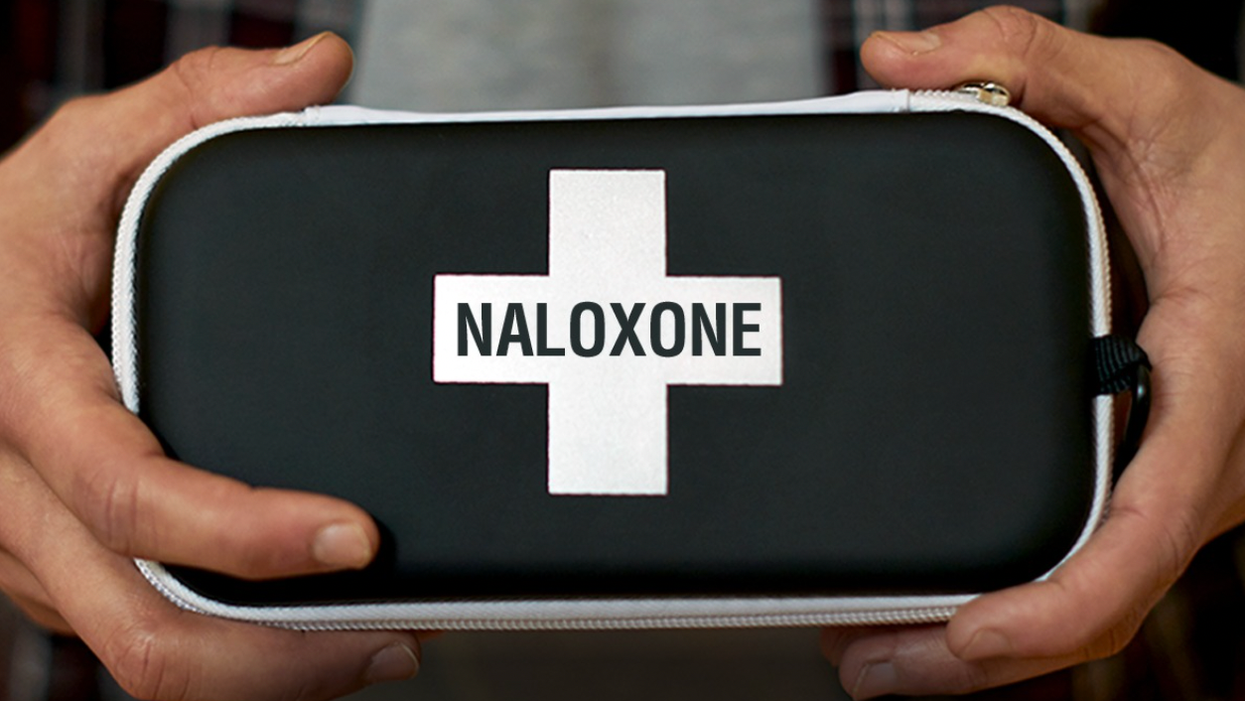 A person holding a Naloxone kit.