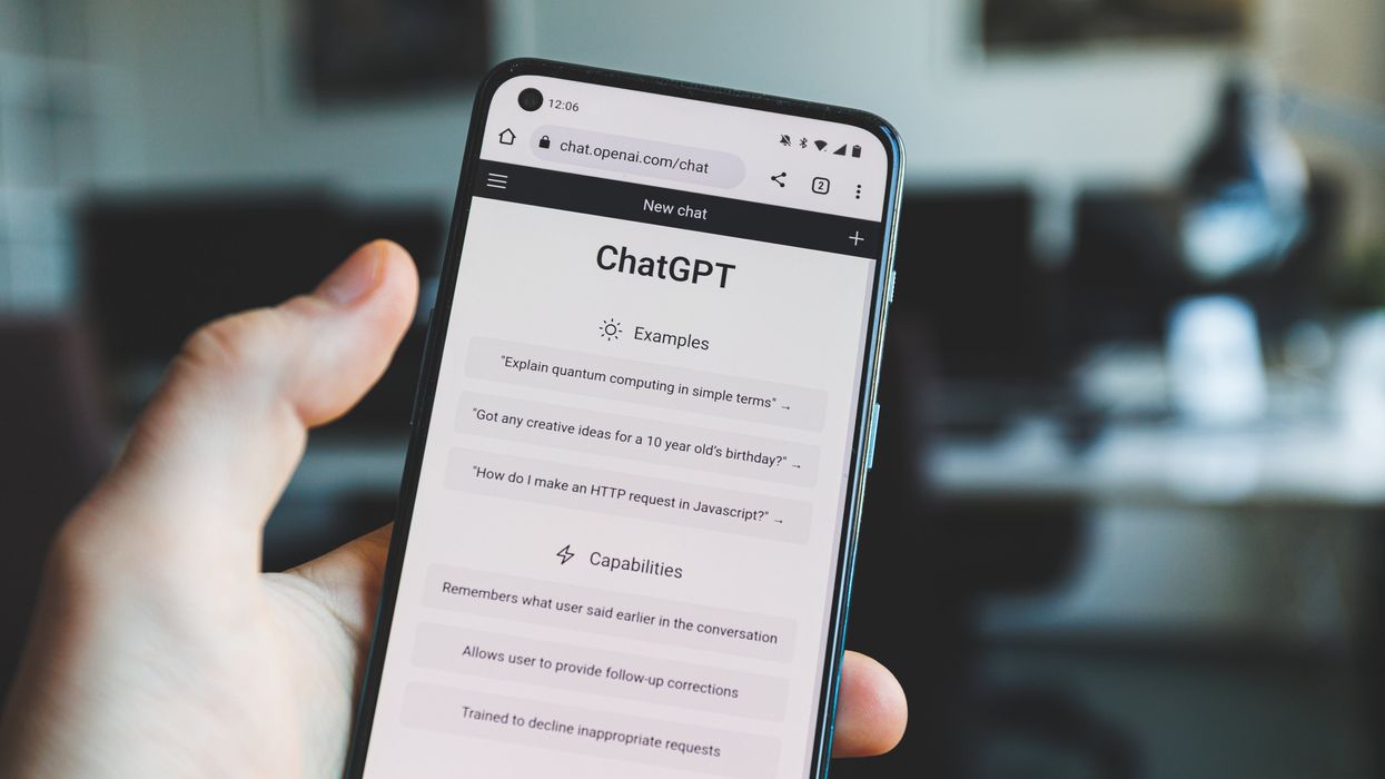A person holding a phone with ChatGPT open on it.
