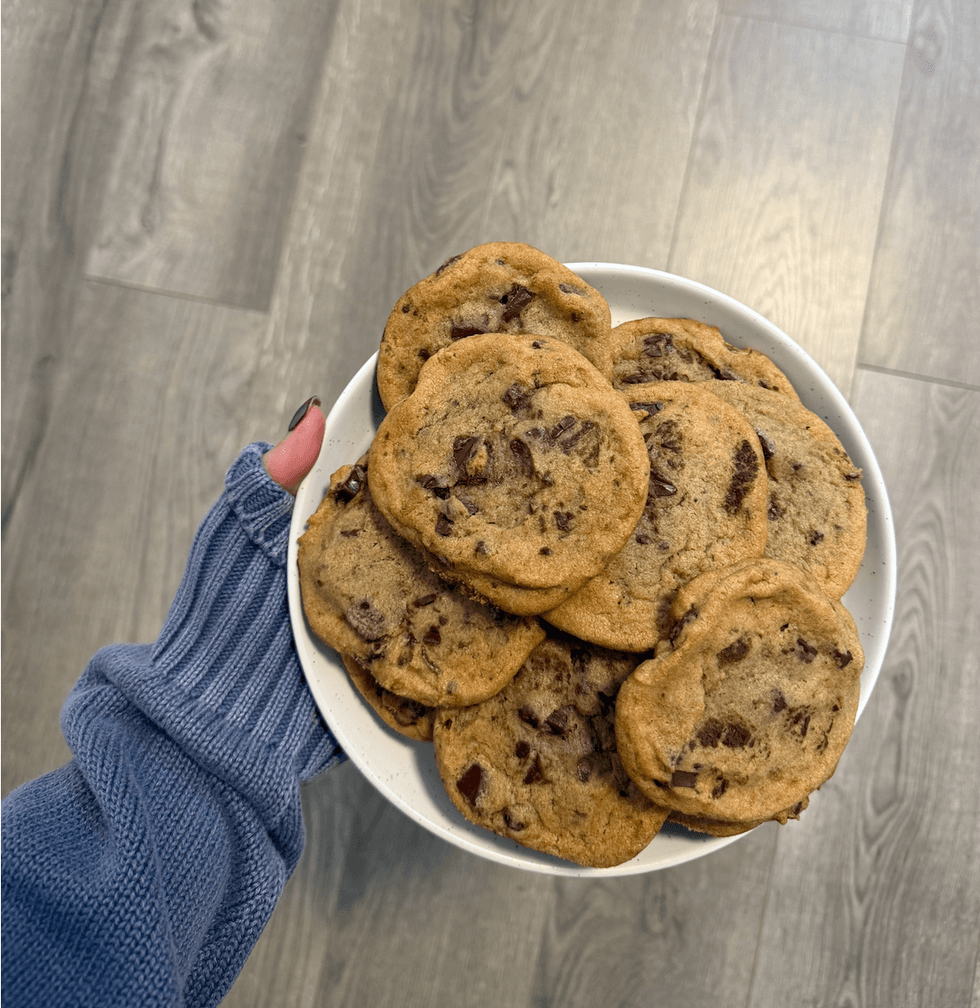 A person holding a plate of cookies.