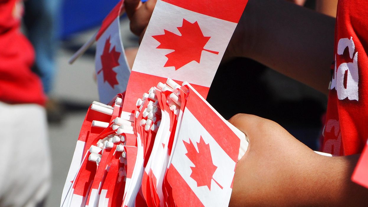 A person holding Canadian flags.