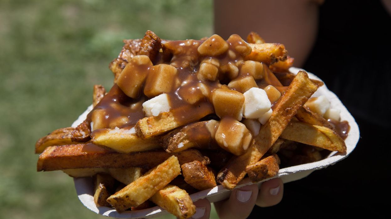 A person holding poutine.