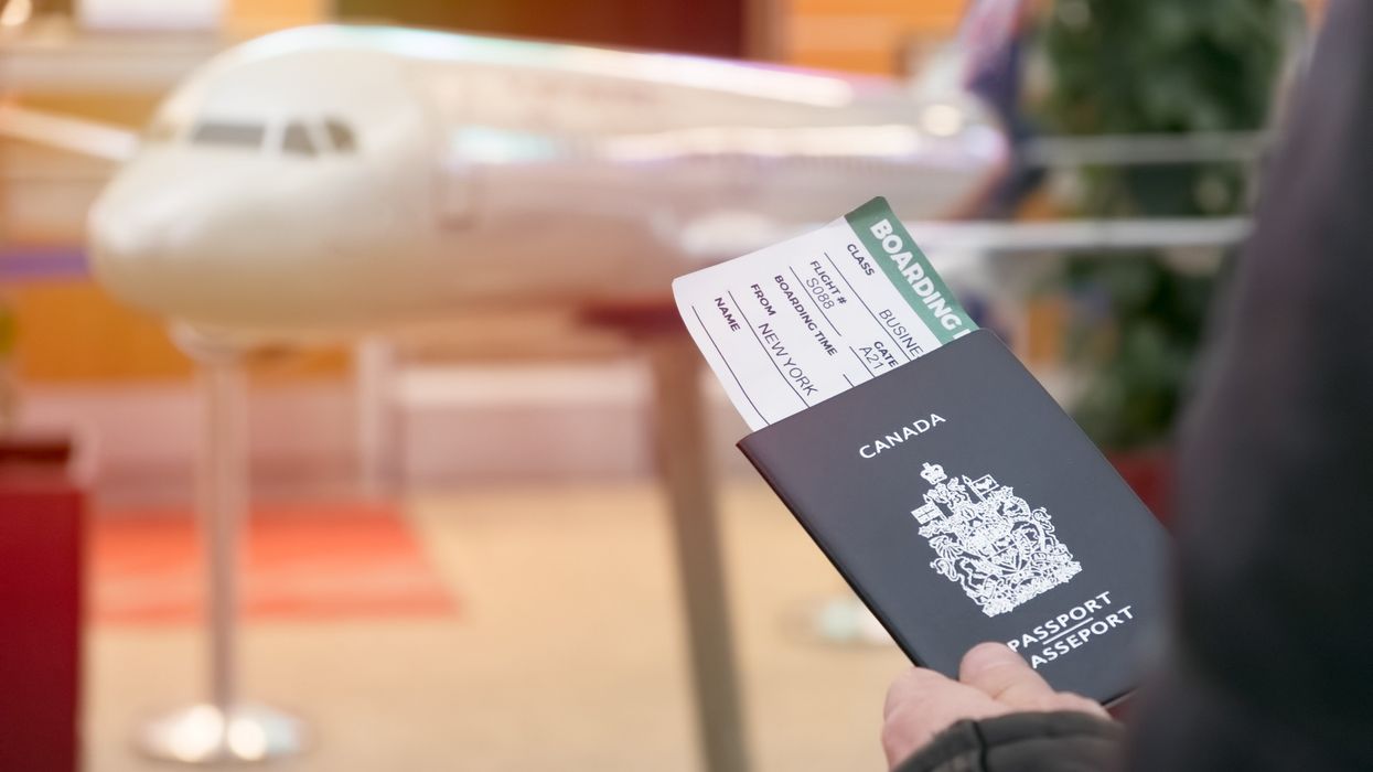 A person holds a Canadian passport and boarding pass.