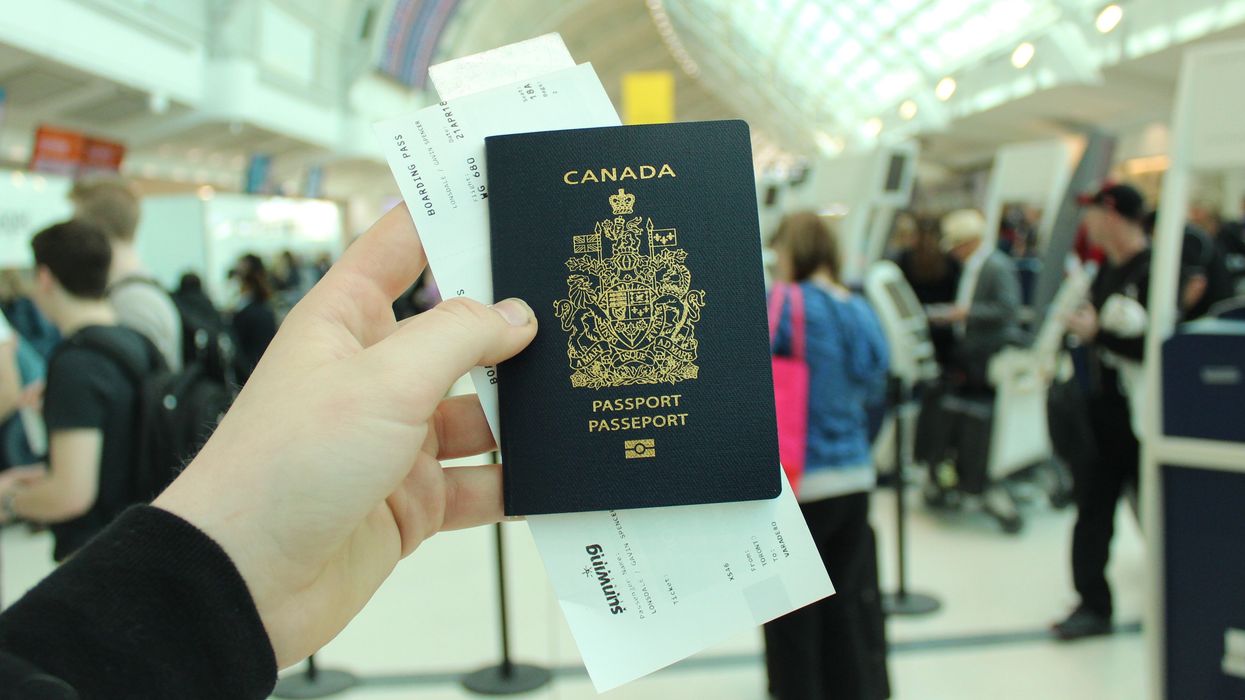 A person holds a Canadian passport in an airport.