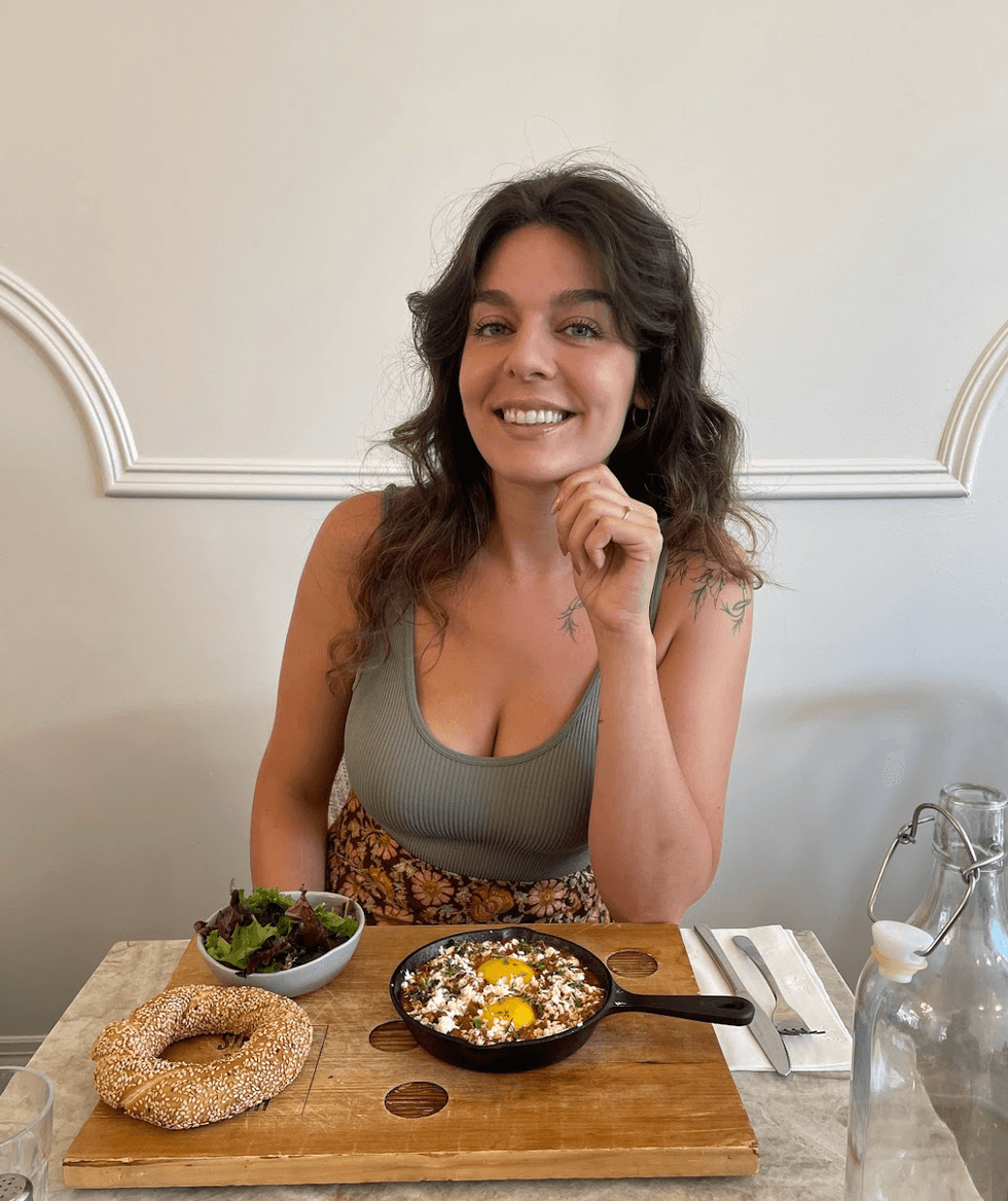 A person in front of a breakfast platter at a restaurant.