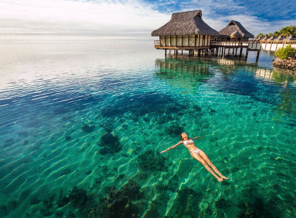 A person in white bikini swimming in Moorea, Tahiti