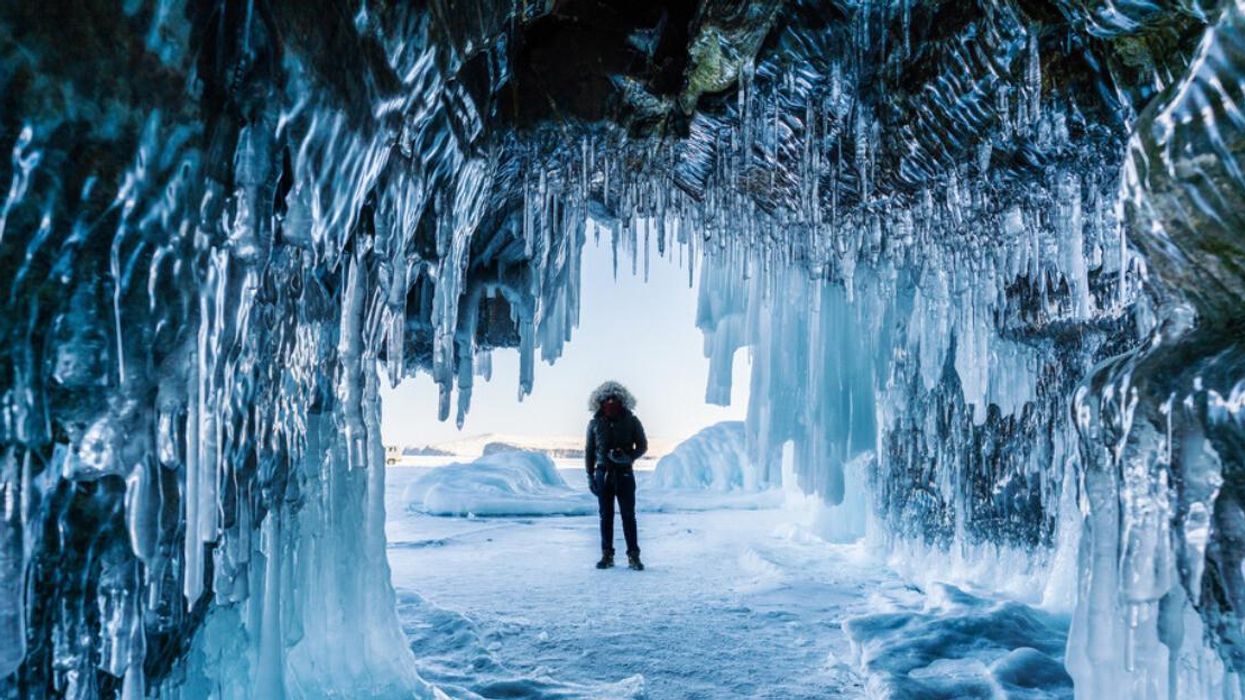 A person investigates an ice cave in Siberia.