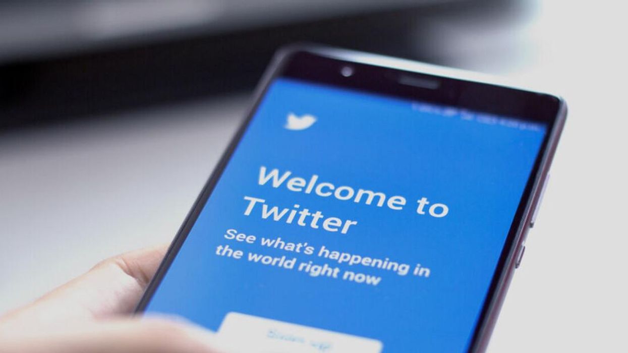 A person opening Twitter on their smartphone.