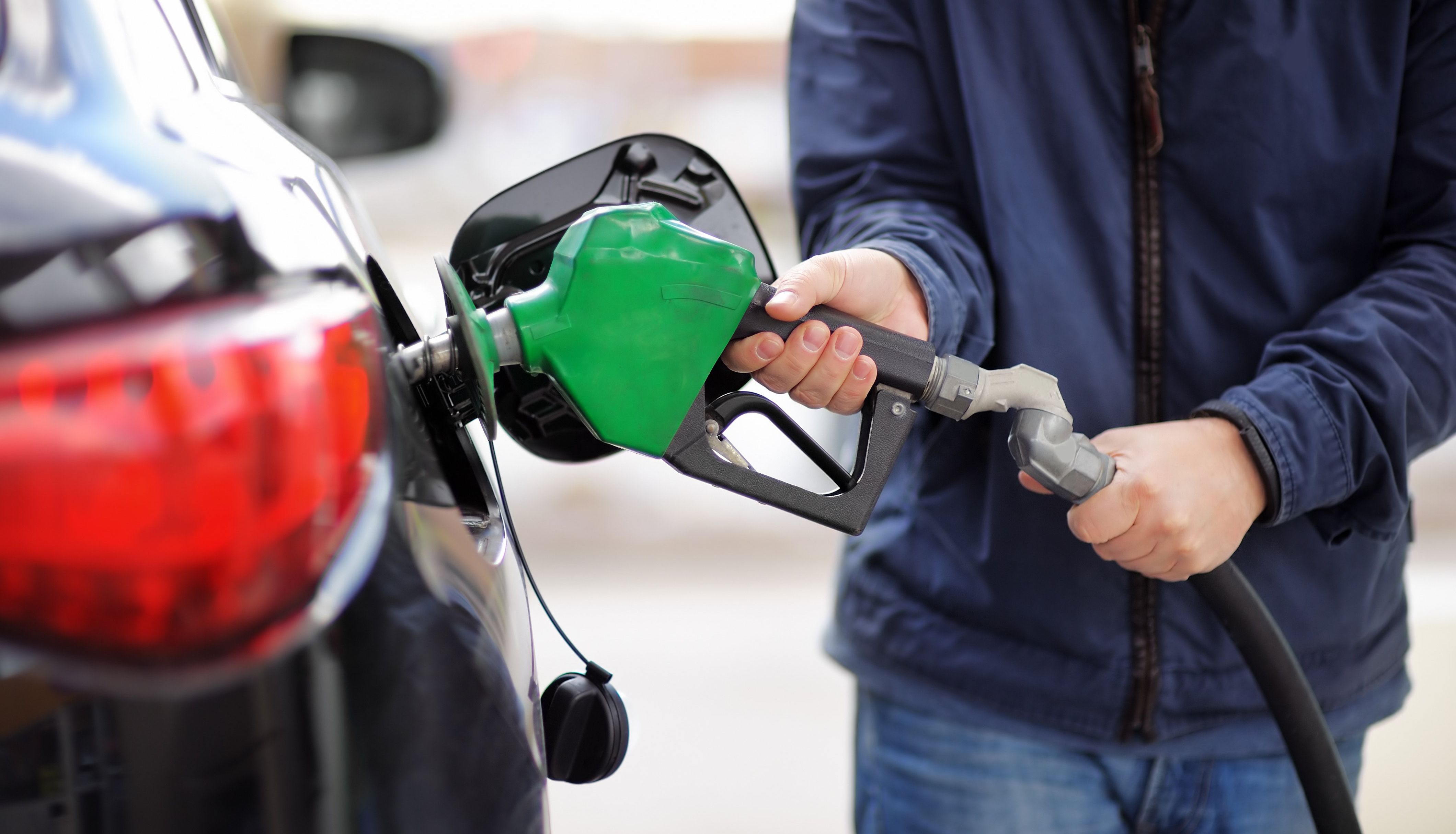 A person pumping their car with fuel.