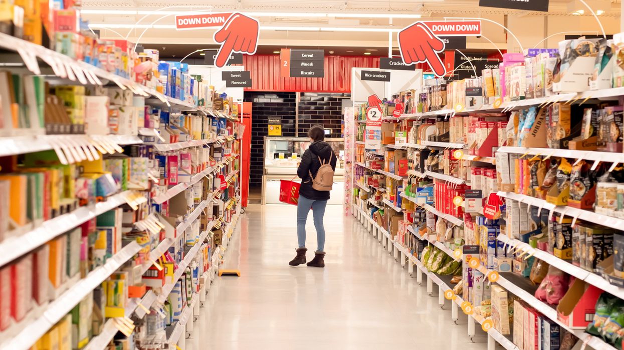 A person standing at the end of a grocery aisle.