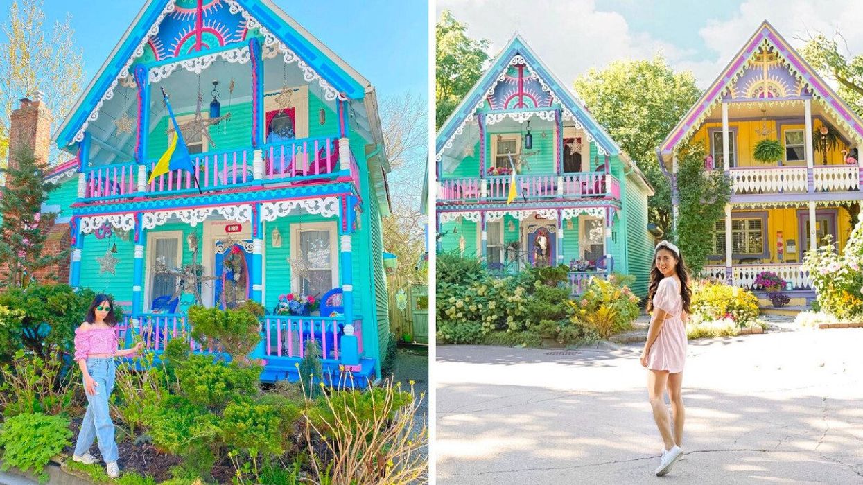 A person standing by a colourful cottage.