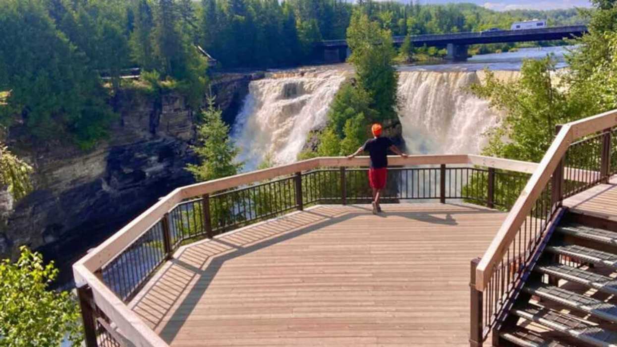 A person standing by a waterfall.
