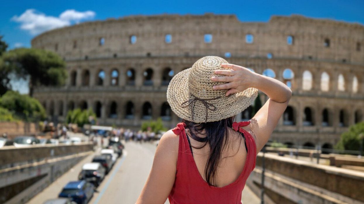 A person standing by the Colosseum.
