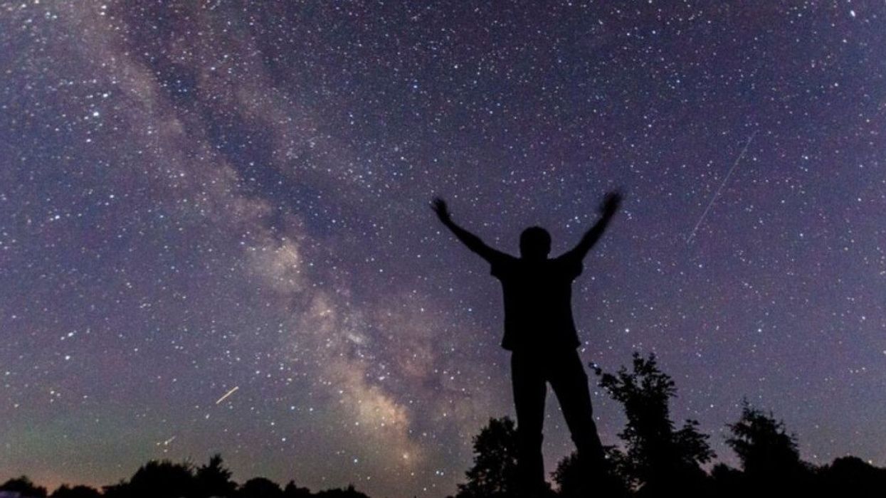 A person standing in front of a night sky.