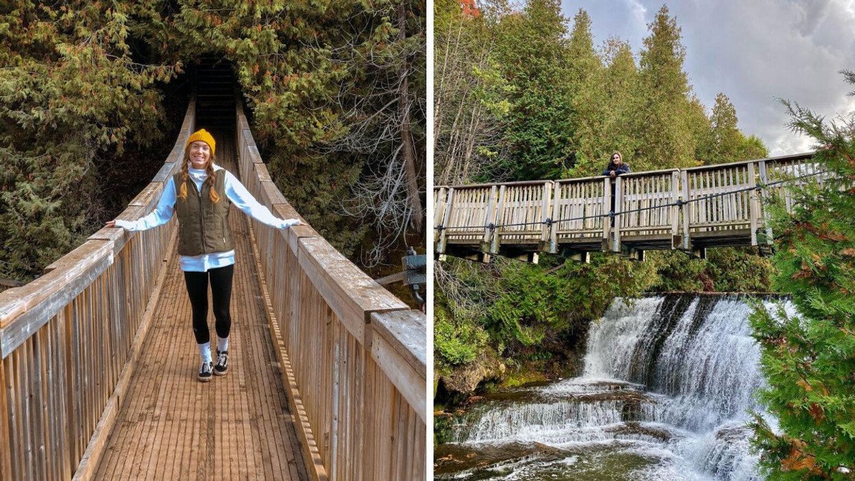 A person standing on a bridge by a waterfall.