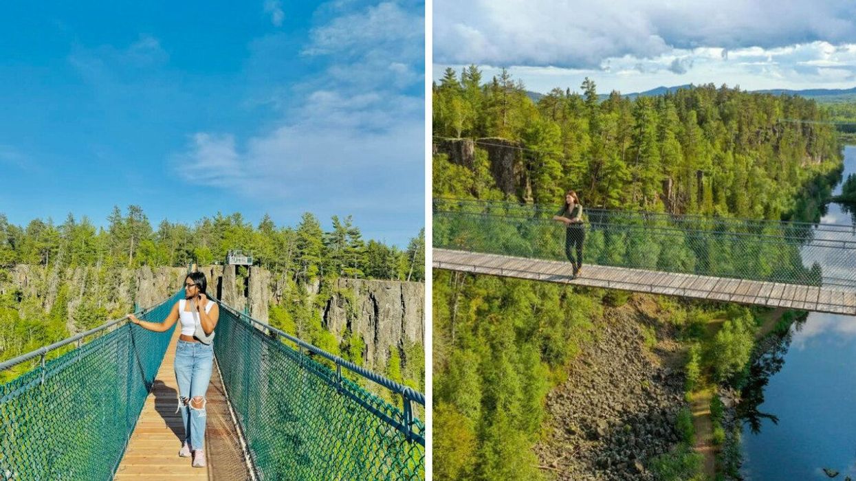 A person standing on a suspension bridge.
