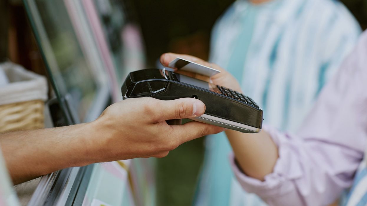 A person tapping a card machine.