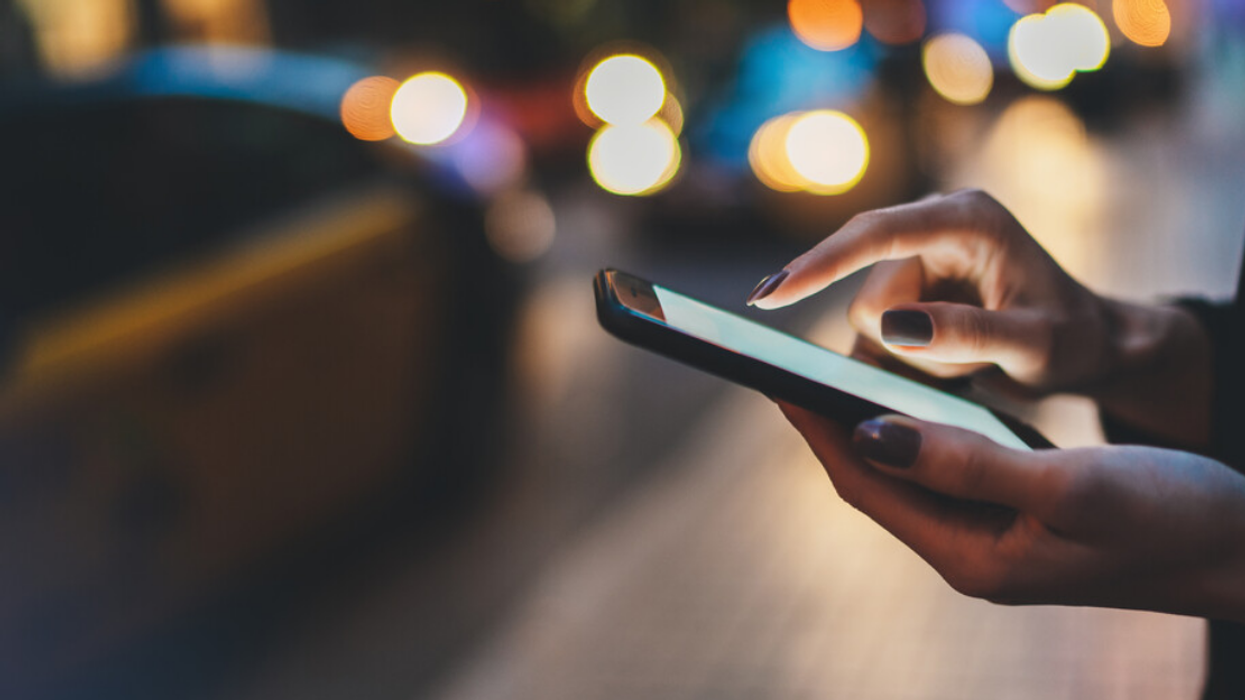 A person texting on the street.