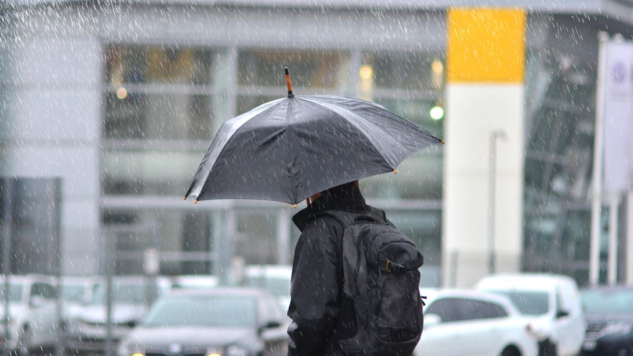 A person walking in the rain with an umbrella.