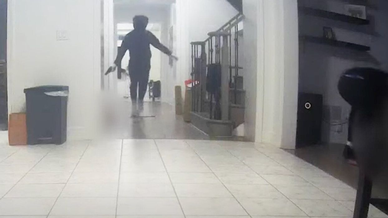 A person wearing all black walking through a home.