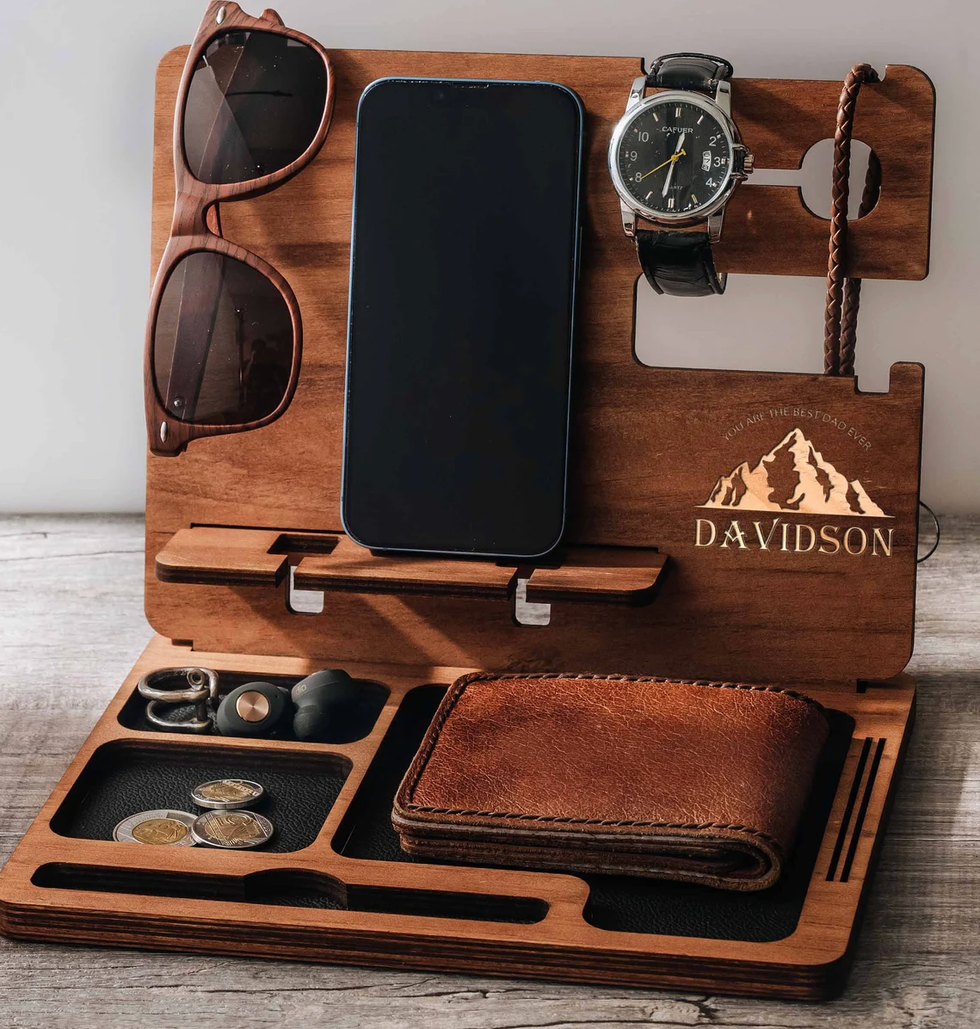 A personalized docking station with a wallet, change, a cellphone, watch and sunglasses on it.
