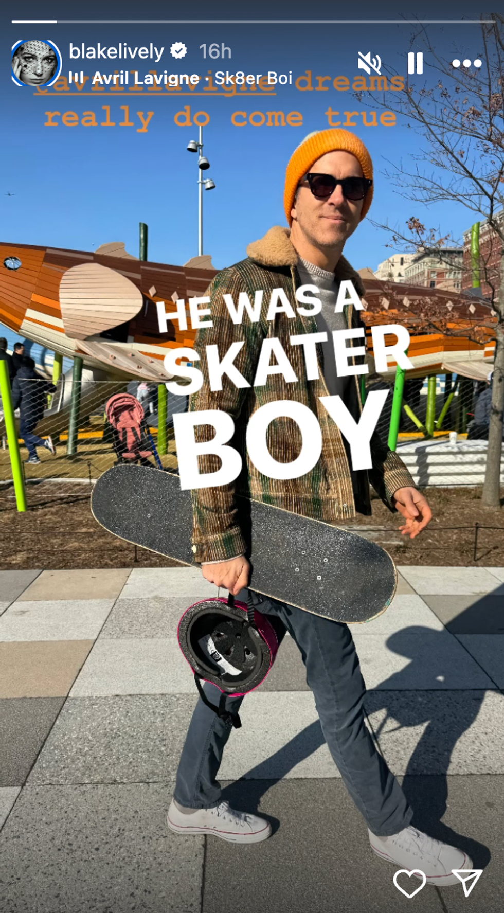A photo of a man holding a skateboard and helmet.