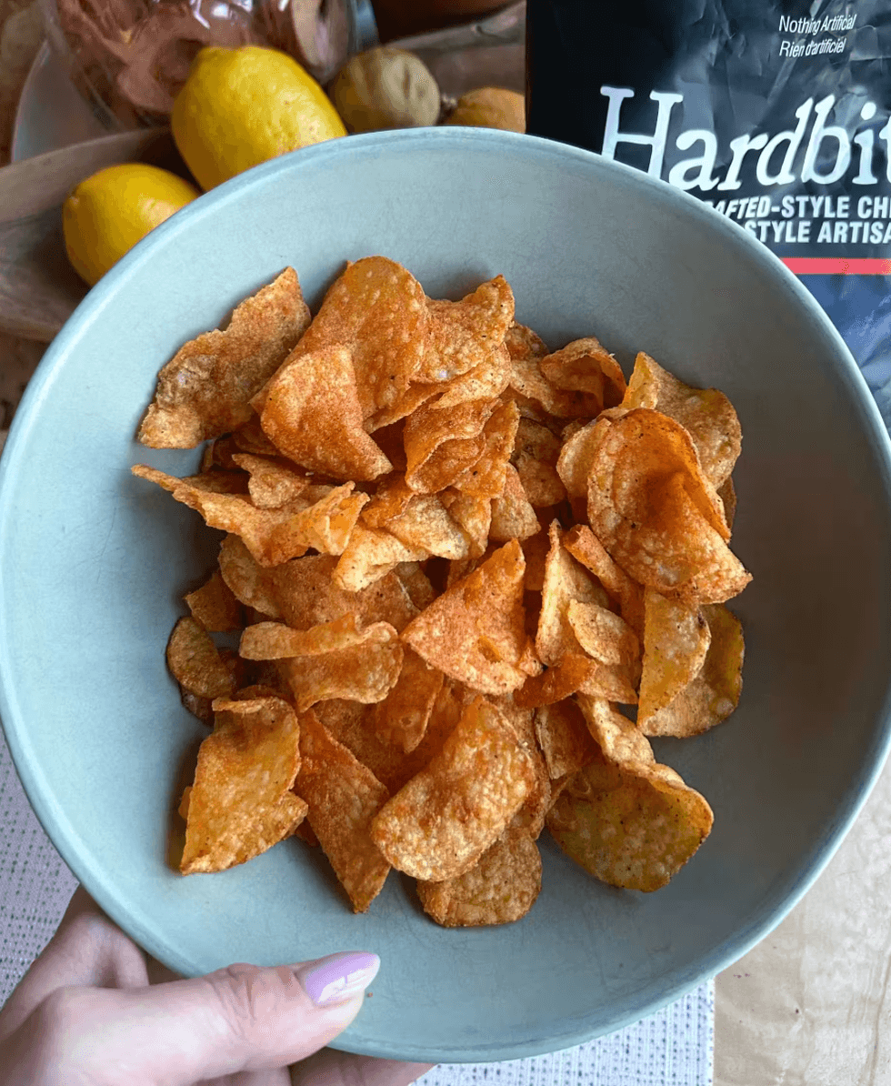 A photo of BBQ flavoured potato chips inside a green bowl