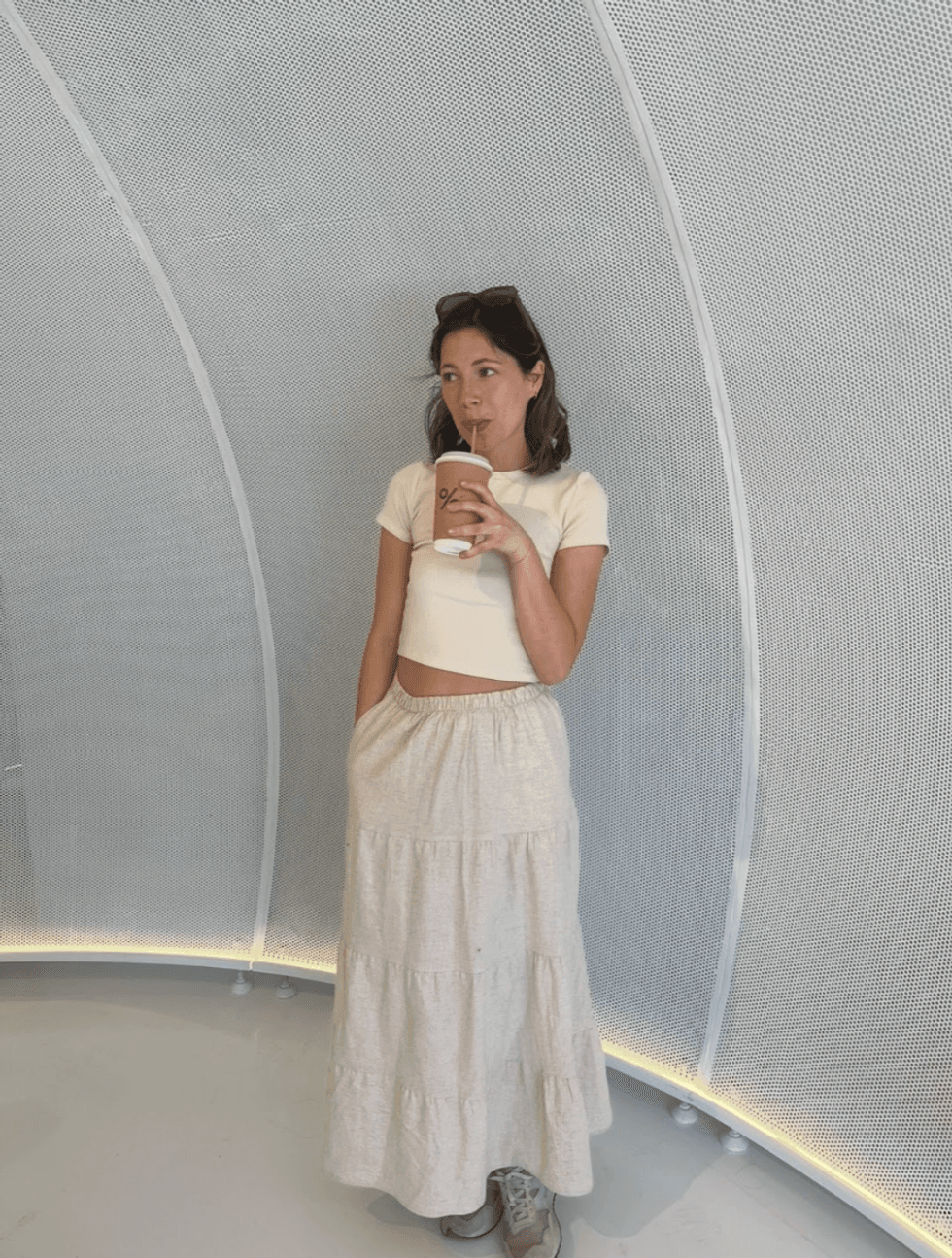 A photo of someone posing with a coffee.