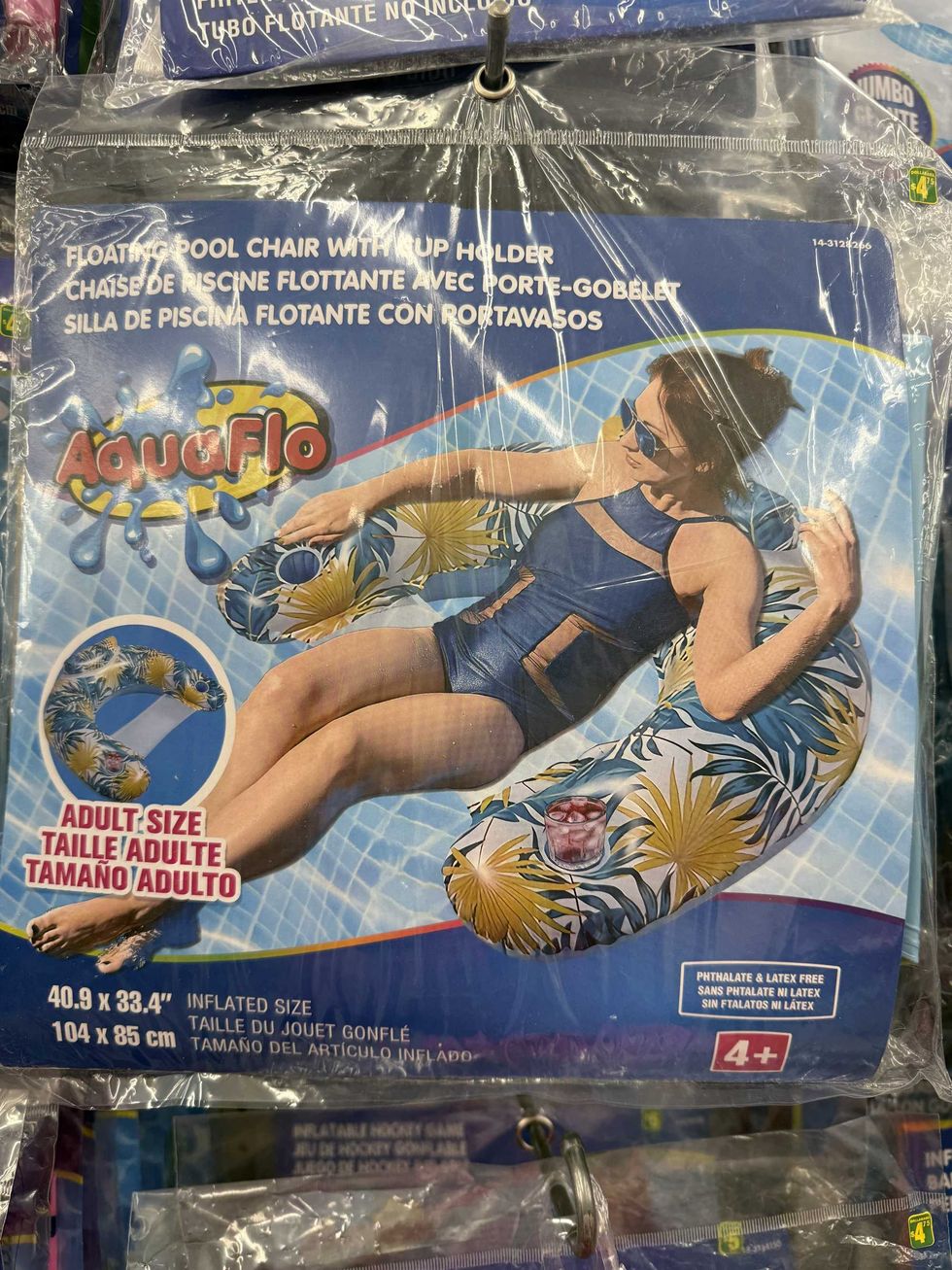 A picture of a woman in a bathing suit on a colourful floatie with a drink in its cup holder.