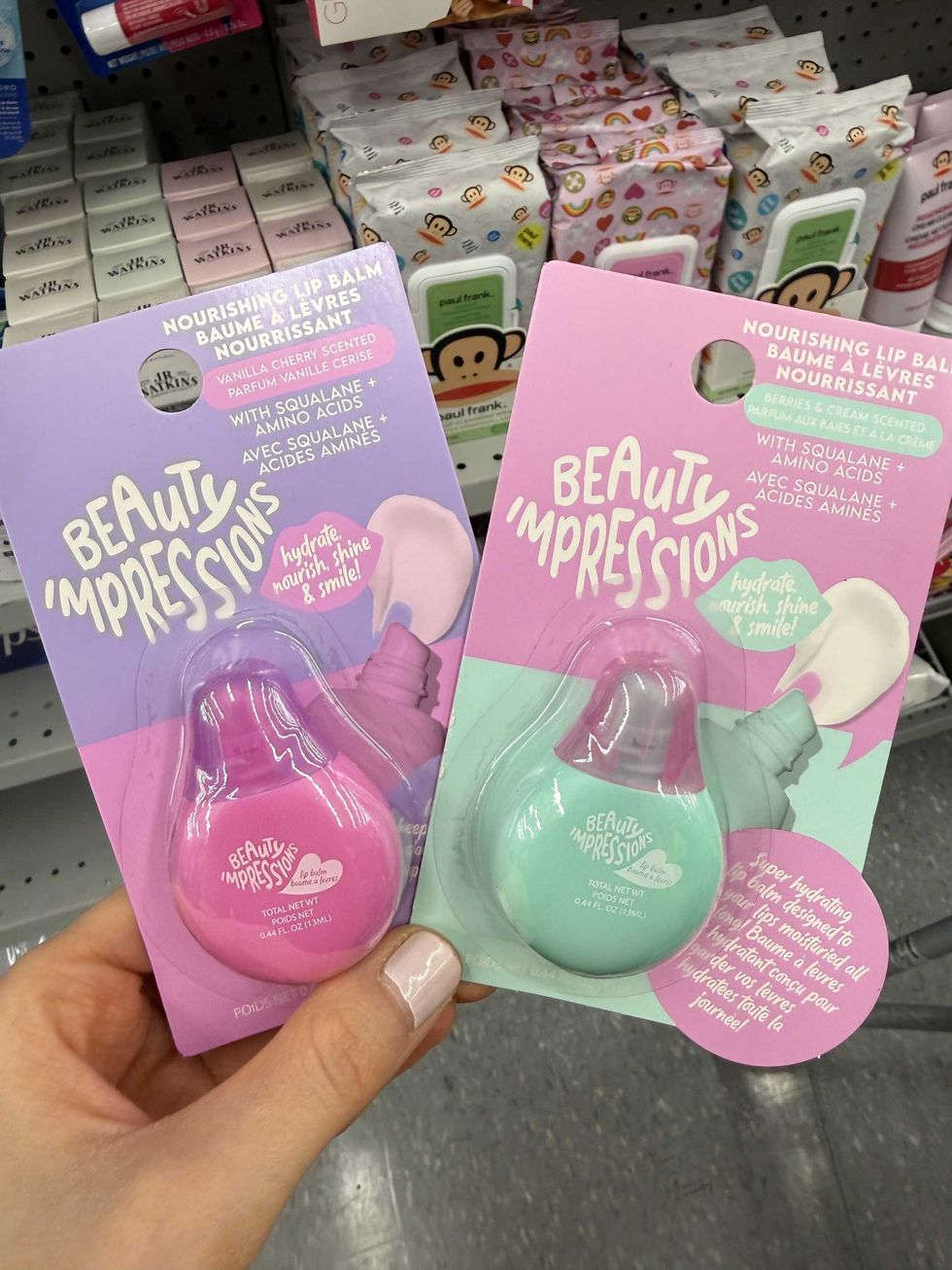 A pink and a green bottle with labels on it that say lip balm.