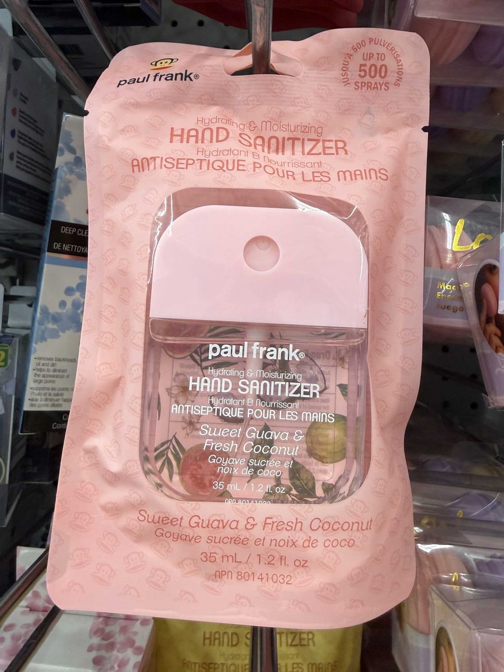 A pink bag with a clear and pink bottle inside that says Paul Frank hand sanitizer on it.